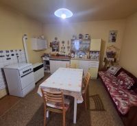 Dining room in a family house with a kitchen table, gas stove, and sofa.