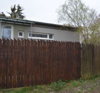 A family house on Húšky in Borský Svätý Jur with a wooden fence and trees.