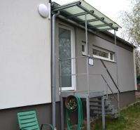 A family house on Húšky Street in Borský Svätý Jur with a metal staircase and a shelter.