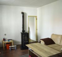 Living room with a fireplace in a family house, sofa, table, wooden decor flooring.