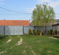A family house in Nižná with a gate, lawn, and a tree in the garden.