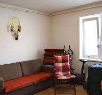 Living room in a family house with a sofa, a chair, and an exercise machine.