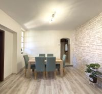 Dining area in a family house with a wooden decor floor and brick cladding.