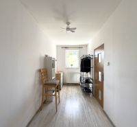 A narrow room with a window and a wooden decor floor in a family house.