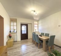 Dining area with wood-patterned flooring and a bench at the table in a family house.