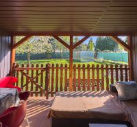 A family house in Orechová Potôň with a terrace and a view of the garden with a wooden fence.
