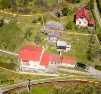 A family house in Štiavnické Bane with a garden and surrounding greenery on a sloping plot.