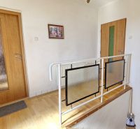 A hallway in a family house with a wooden decor floor and doors.