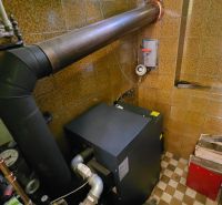 The utility room in a family house with a boiler and firewood for heating.