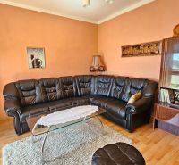 Living room in a family house with a leather sofa and a wooden decor floor.