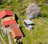 A family house in Štiavnické Bane with a red roof, a garage, and a green garden.
