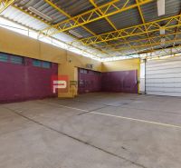 Yellow structural elements in a warehouse hall with large garage doors and colorful walls.
