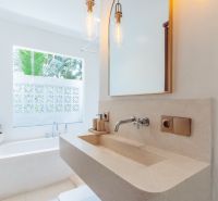 A bathroom in a villa with an elegant sink and a large window.