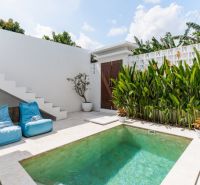 A villa in Bali with a private pool, loungers, and greenery in an intimate courtyard.