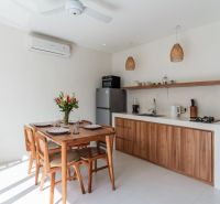 A kitchen in a villa with wooden decor, a table, flowers, and a ceiling fan.