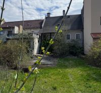 A family house in Kremnica with a spacious garden, shrubs, and newly growing greenery.