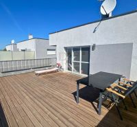 The terrace of a family house in Boldog with a lounger, table, and flooring with a wooden decor.