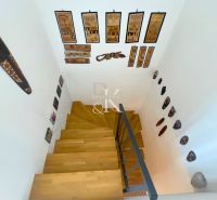 A staircase with a wooden decor floor and African masks in a family house.