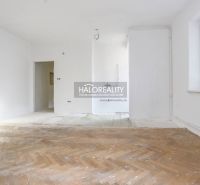 A spacious room in a 3-room apartment with a wooden decor floor and white walls.