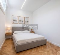 A bedroom in a three-room apartment with a wooden decor floor and cozy lighting.