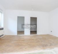 A spacious room in a 3-room apartment with a wooden decor floor, white walls, and a window.