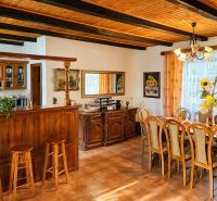 Dining area with wooden furniture and a bar counter in a family house.