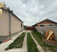 The yard by the family house in Hula, surrounded by a fence, next to cycling and wooden embankments.