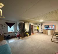 Living room in a family house with comfortable furnishings and a TV on a dresser.