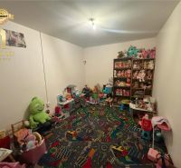 Children's room in a family house with toys and shelves full of stuffed animals.