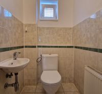 A bathroom with white sanitary ware and tiles in a family house.