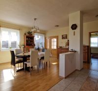 A bright dining room in a family house with a wooden decor floor and furniture.