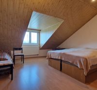 Attic room in a family house with wooden paneling and a wooden decor floor.