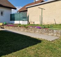 The garden of a family house in Spišský Štvrtok with a bench and flower beds.