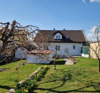 A garden at a family house in Spišský Štvrtok with blooming trees and a lawn.