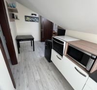 Interior of a family house with a kitchen, microwave, table, and floor with a wood decor.