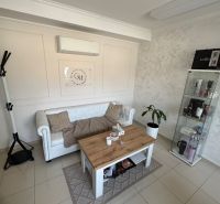 Living room with a white sofa, coffee table, and display cabinet in a family house.