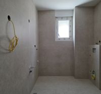 A bathroom in a 3-room apartment with tiles and a window on the wall.