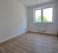 A bright room with a window and a wooden decor floor in a 3-room apartment.