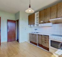 A kitchen in a family house with a wooden decorative floor and white tiles.
