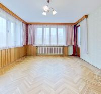 Living room in a family house with large windows and a wooden decor floor.