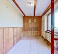 The interior of a family house with a wooden decor floor and wooden wall paneling.