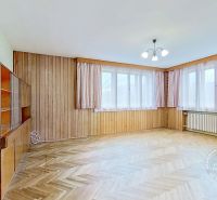 A room in a family house with a wooden decor floor and large windows.
