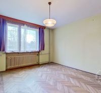 A room in a family house with a wooden decor floor and curtains on the window.