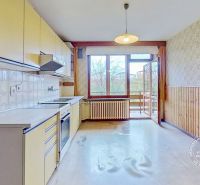 Family house kitchen with a countertop and access to the balcony, floor with wooden decor.