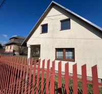 A family house in Vislanka with white plaster and a red fence.