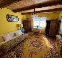 Yellow living room with carpets and rustic furniture in a family house.
