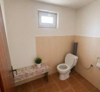 Bathroom with toilet and decorated bench in a family house.
