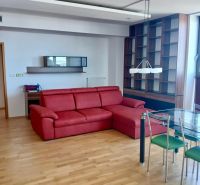 A red sofa set and a glass table in a 2-room apartment with a wooden decor floor.