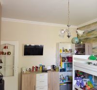 A children's room in a three-room apartment with a bunk bed and a colorful carpet.