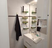 A bathroom with a wall-mounted sink and storage space in a 3-room apartment.